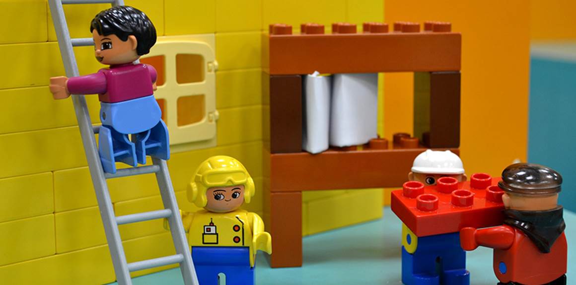 Legogubbar som bygger hus
