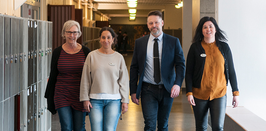 Lärare som går i korridor på skola