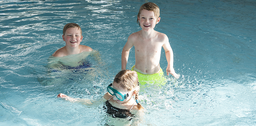 Tre barn som badar i simhallen i Hofors