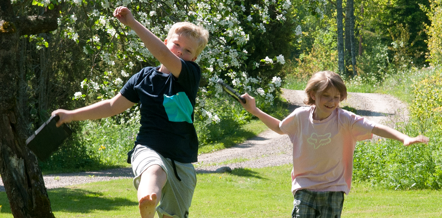 Två pojkar som hoppar med ipads i händerna